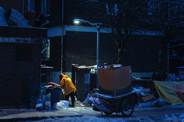 Collecting scraps of cardboard in wintry night stock photo