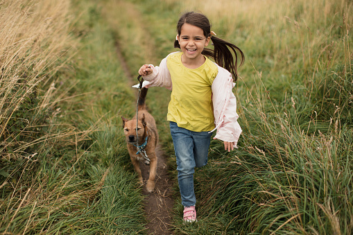 A young girl running on a coastal path in Northumberland