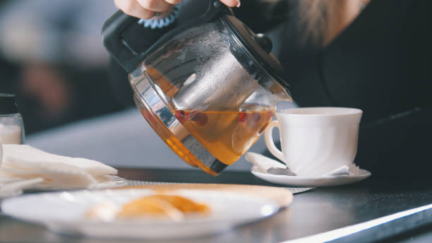 istock Woman in cafe pouring berry tea in a cup 904230988
