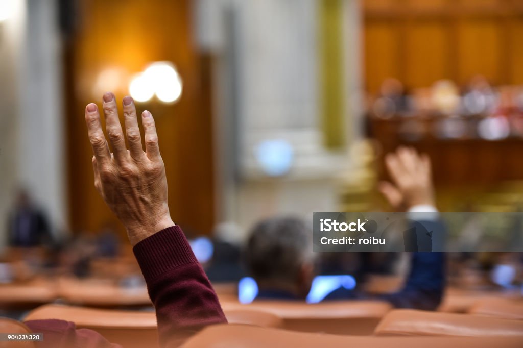 Hand of a man raised in the air during a voting procedure Citizenship Stock Photo