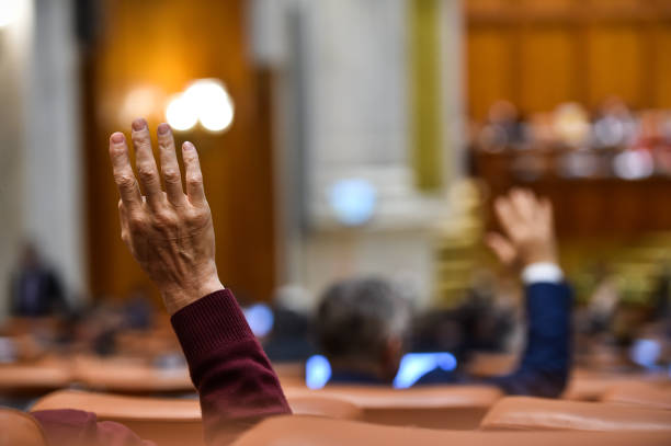 Hand of a man raised in the air during a voting procedure stock photo