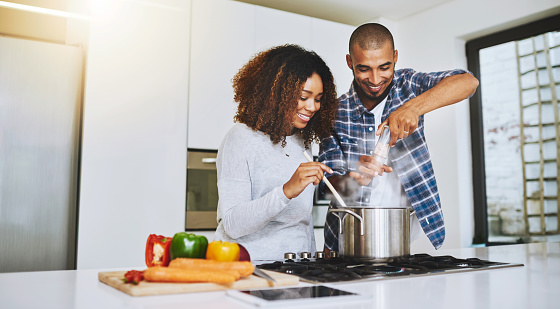 Shot of a young couple cooking together at home
