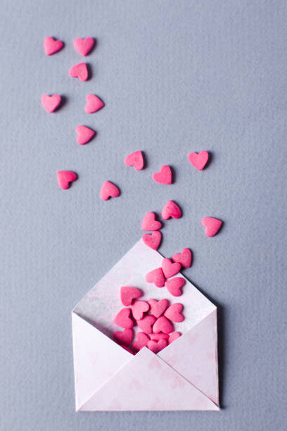 istock Envelope with heap of small hearts on gray background. Valentines Day concept. Top view, vertical photo 904245930
