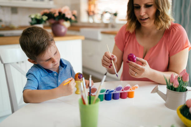 istock Young mother and her son having fun while painting eggs for Easter 904250518