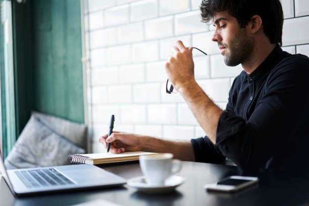 istock Young concentrated hipster guy creating article for personal website.Intelligent  bearded male preparing for upcoming quality control testing and solving problems writing report analyzing information 904254518