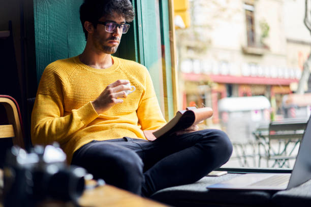 istock Handsome male author of popular article in newspapers drinking espresso for breakfast proofreading his text in notebook thinking over creative solutions of improvement sitting in comfortable cafe 904254642