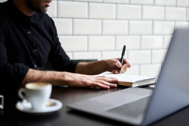 istock Cropped image of attractive student in casual wear preparing homework making research using internet sources.Professional journalist writing article for publication in magazine sitting indoors 904254660