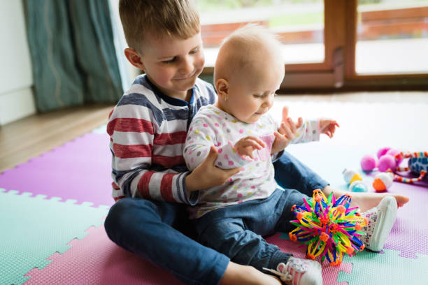 istock Cute little children playing while sitting on carpet 904254738
