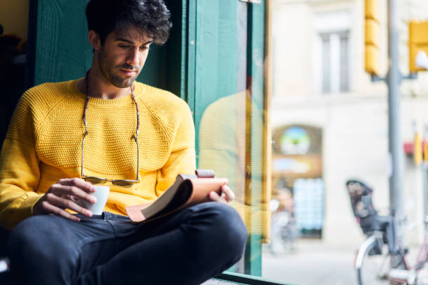 istock Handsome bearded male talented journalist proofreading his article before sending to editor and publishing in popular magazine sitting in comfortable coffee shop with cup of favorite espresso 904256868