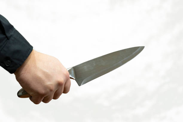 istock Knife in hand in withe background. The steel shine of the knife blade. 904257448