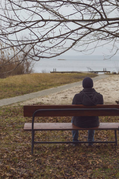 istock The man is sitting on the bench and looking at the river. 904261036