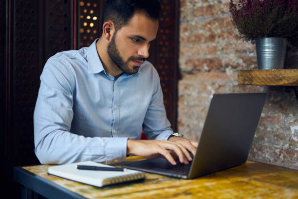 istock Concentrated experienced male entrepreneur communicating through online chat with skilled IT professionals working on creating website for corporation sitting in coworking space using laptop 904264334