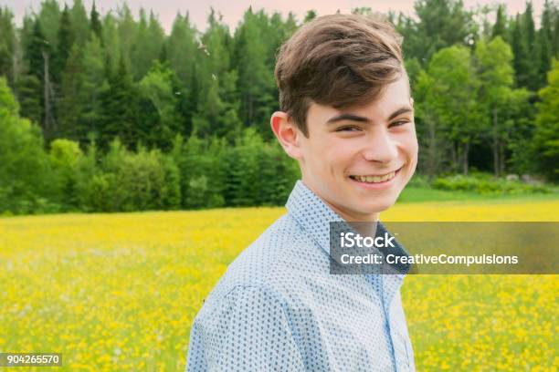 Teenage Boy Running And Walking In A Yellow Field At Sunset Stock Photo - Download Image Now