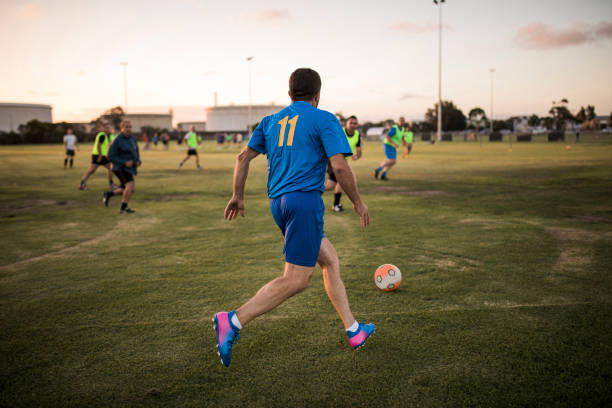 Football Player Going to Kick Football Male footballer lining up to kick the football. soccer soccer ball kicking adult stock pictures, royalty-free photos & images