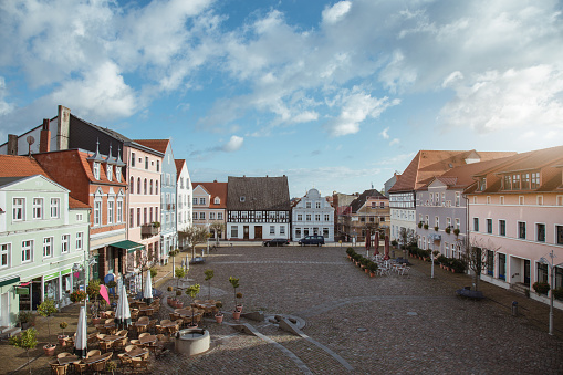 Public city square ueckermünde with some residential buildings ,hotel and a cafe, on a sunny autumn day.