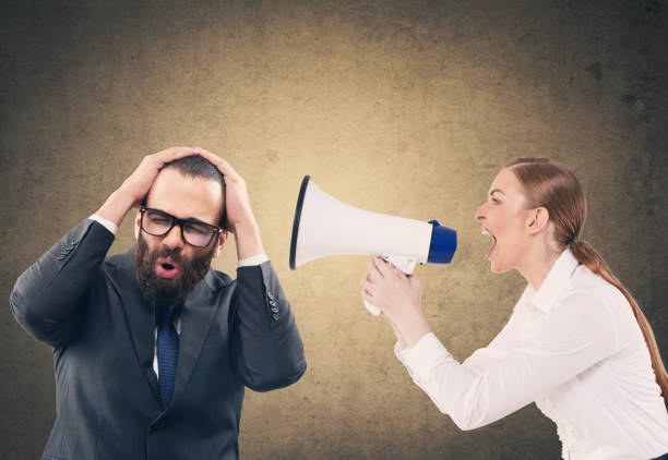 istock Woman screaming through megaphone at scared businessman 904277166