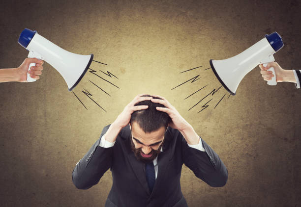 People screaming through megaphone at scared businessman People shouting commands through megaphone at scared businessman in front of wall asian suit man cross hand stock pictures, royalty-free photos & images