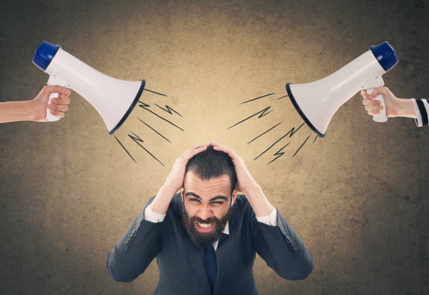 People screaming through megaphone at scared businessman People shouting commands through megaphone at scared businessman in front of wall asian suit man cross hand stock pictures, royalty-free photos & images