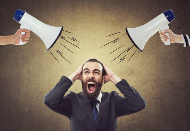 istock People screaming through megaphone at scared businessman 904277506