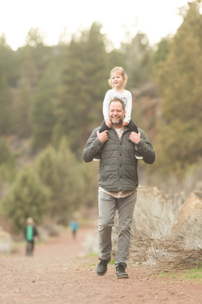 istock Daughter Rides Dad's Shoulders on a Nature Hike 904281042