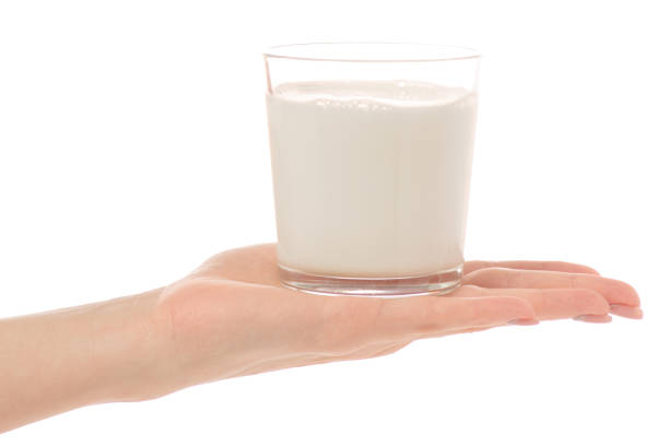 istock Glass of milk in a hand 904281476