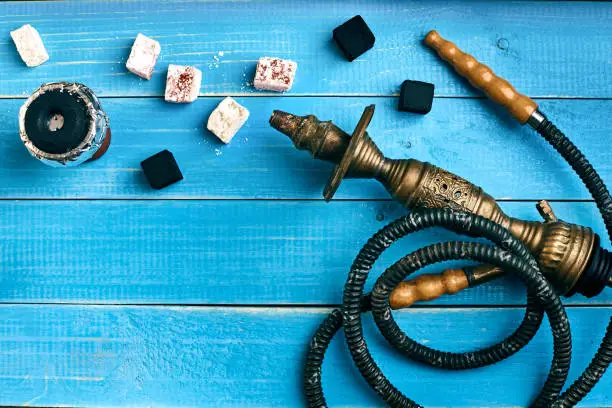 Photo of Parts of the hookah on blue wooden background. Hookah accessorie