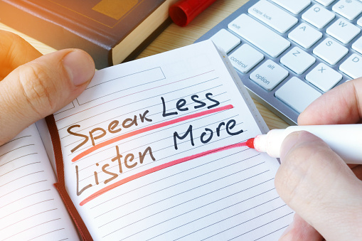 Man writing quote Speak less listen more.