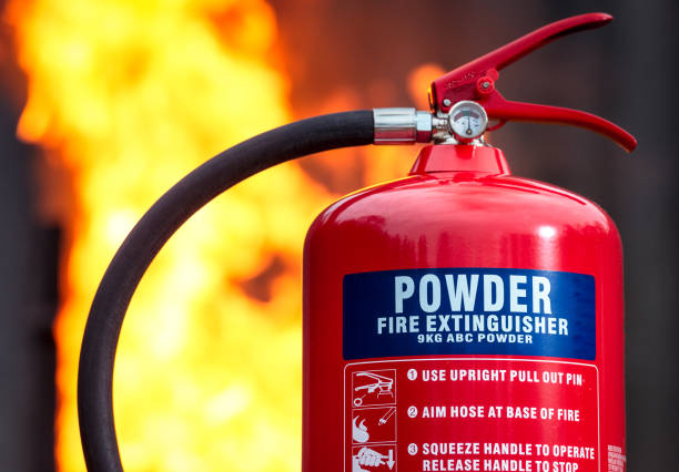 istock ABC Powder Fire Extinguisher with flames behind 904290394