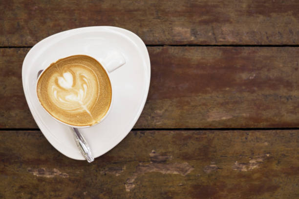 istock latte art coffee in white cup on old wooden table. Breakfast, morning concept 904302056