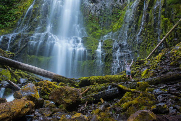 istock Woman Stands with her Arms Raised at Proxy Falls 904311232