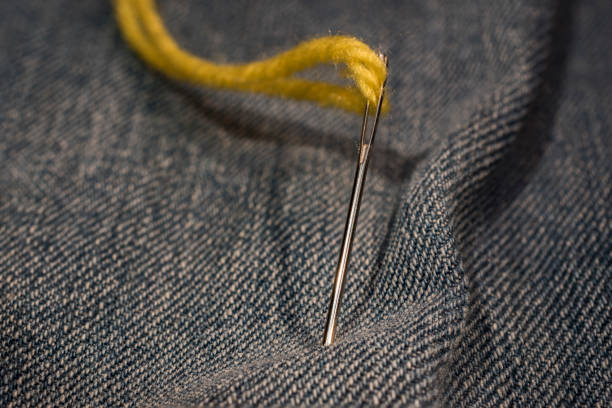 istock close up of yellow needle thread on jeans cloth 904312044