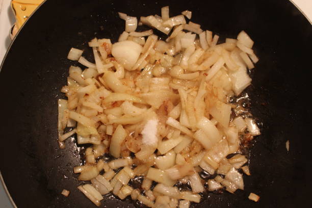 istock Caramelized onions being made in a large wok type pan 904313070