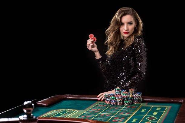 Woman playing in casino. Woman stakes piles of chips playing rou stock photo