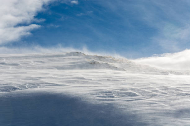 istock Snow blowing over the edge of a mountain in Austria 904319802