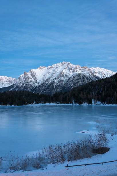 il lago ghiacciato lautersee vicino a mittenwald con montagne innevate durante l'ora blu - lautersee lake foto e immagini stock