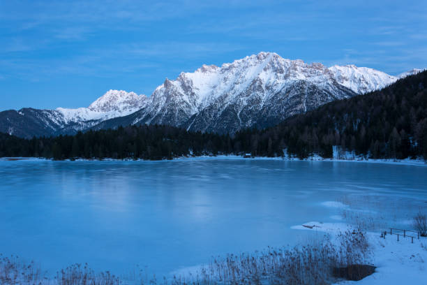 il lago ghiacciato lautersee vicino a mittenwald con montagne innevate durante l'ora blu - lautersee lake foto e immagini stock