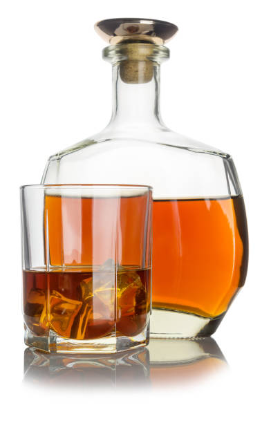 istock glass with cognac and ice, next bottle with cognac on white background 904328512