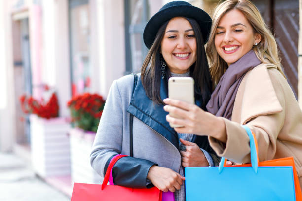 istock Two smiling young woman with shopping bag 904333012