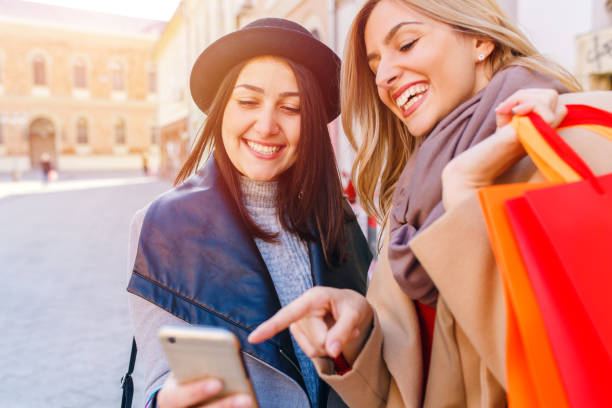 istock Two smiling young woman with shopping bag 904336014