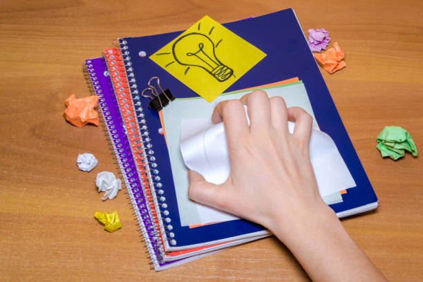istock Idea concept with crumpled paper lightbulb and colored sheet with pen on wooden desktop 904344356