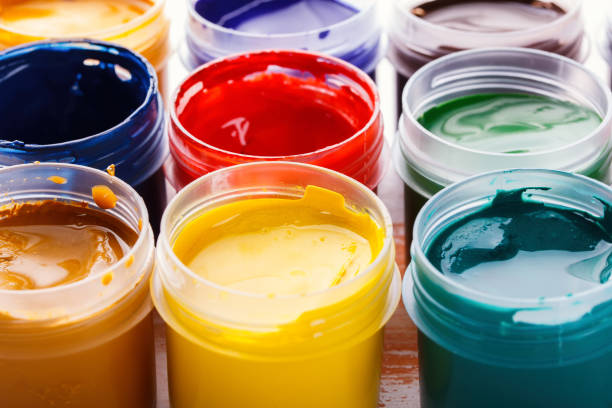 istock Plastic cans of multi-colored gouache on a wooden painted table 904347498