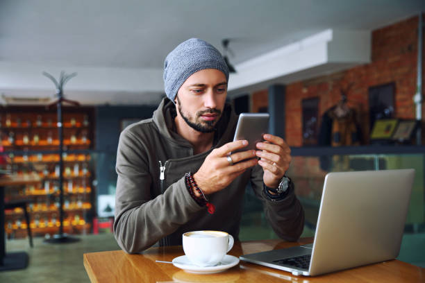istock Young handsome hipster guy at the restaurant using a mobile phone 904349794