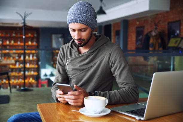 istock Young handsome hipster guy at the restaurant using a mobile phone 904351248