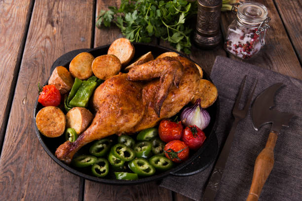 istock fried chicken half with potatoes and tomatoes in the frying pan 904352274