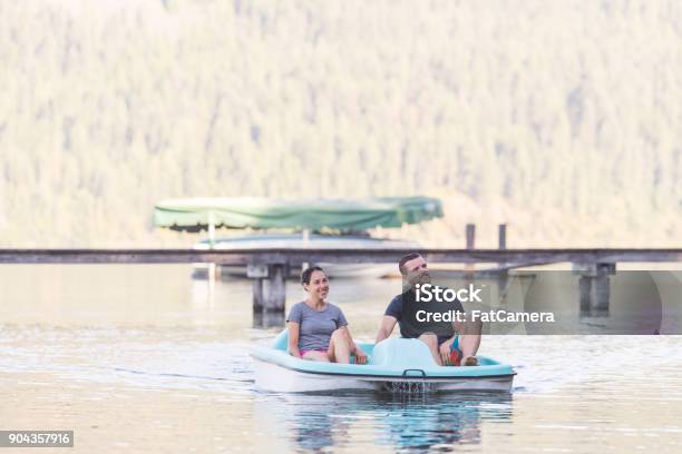 Pareja Joven En Un Remo De Barca De Pedales Alrededor Del Lago Foto de stock y más banco de imágenes de Bote de pedales