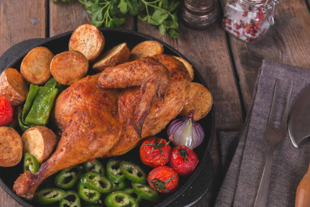istock fried chicken half with potatoes and tomatoes in the frying pan 904357962