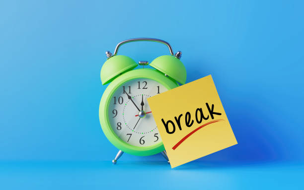 Alarm Clock And A Yellow Post It Not Over Blue Background Green alarm clock with a yellow post it note attached over bright blue background. Break writes on post it note. Reminder concept. Horizontal composition with copy space. break time stock pictures, royalty-free photos & images