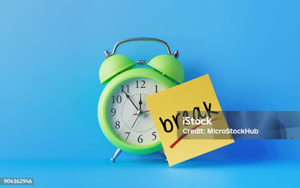 Alarm Clock And A Yellow Post It Not Over Blue Background Stock Photo - Download Image Now