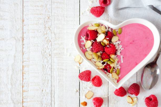 istock Raspberry smoothie in a heart bowl with superfoods, side border 904371042