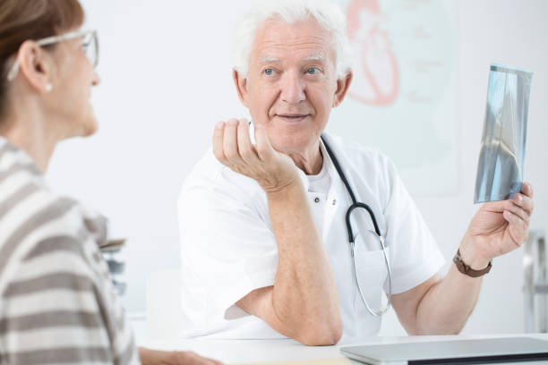 istock Senior doctor holding X-ray image 904377640